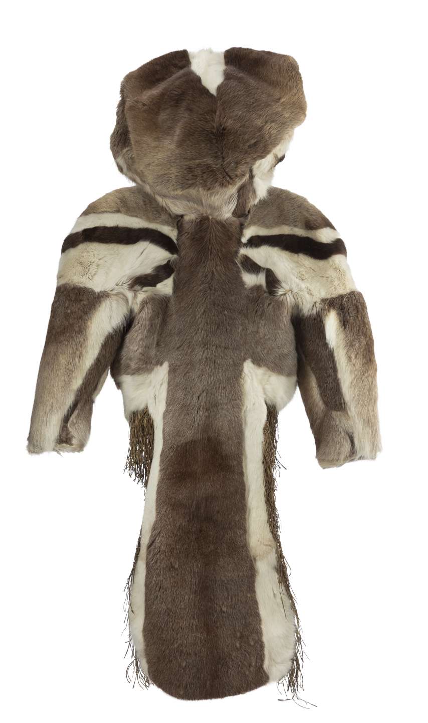 Manteau en fourrure brune, vu de derri&egrave;re, avec le capuchon relev&eacute;. Des bandes de fourrure claire et fonc&eacute;e forment un motif sym&eacute;trique sur les &eacute;paules. Le manteau, coup&eacute; sur les c&ocirc;t&eacute;s, pr&eacute;sente un long pan arri&egrave;re carr&eacute;, bord&eacute; de fourrure blanche et orn&eacute; de franges, sauf &agrave; l&rsquo;extr&eacute;mit&eacute;.