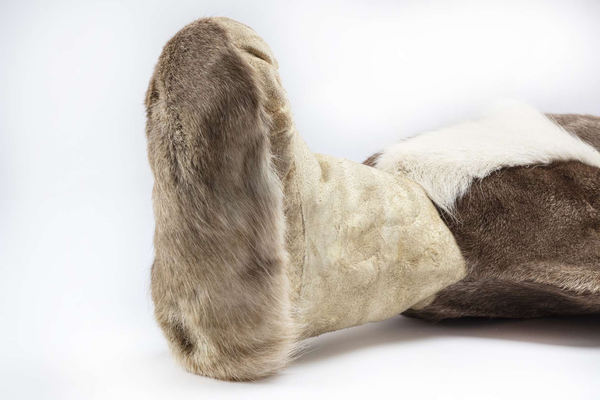 Vue rapproch&eacute;e d&rsquo;une botte allong&eacute;e sur le c&ocirc;t&eacute;, mettant en &eacute;vidence la semelle en fourrure brun clair.