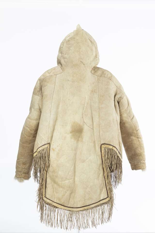 Veste en cuir beige vue de dos avec le capuchon relev&eacute;, pointu. La veste pr&eacute;sente un pan arri&egrave;re carr&eacute; et deux c&ocirc;t&eacute;s plus courts, d&eacute;cor&eacute;s de franges.