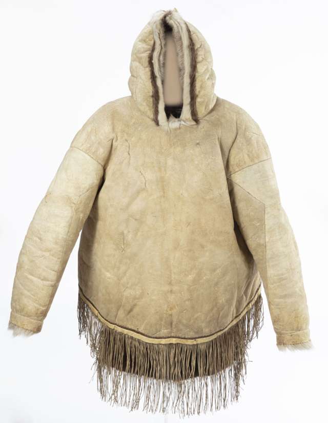 Veste en cuir beige vue de face avec le capuchon relev&eacute;. La veste est d&eacute;cor&eacute;e de franges au bas et de fourrure blanche le long de la bordure du capuchon et aux poignets.