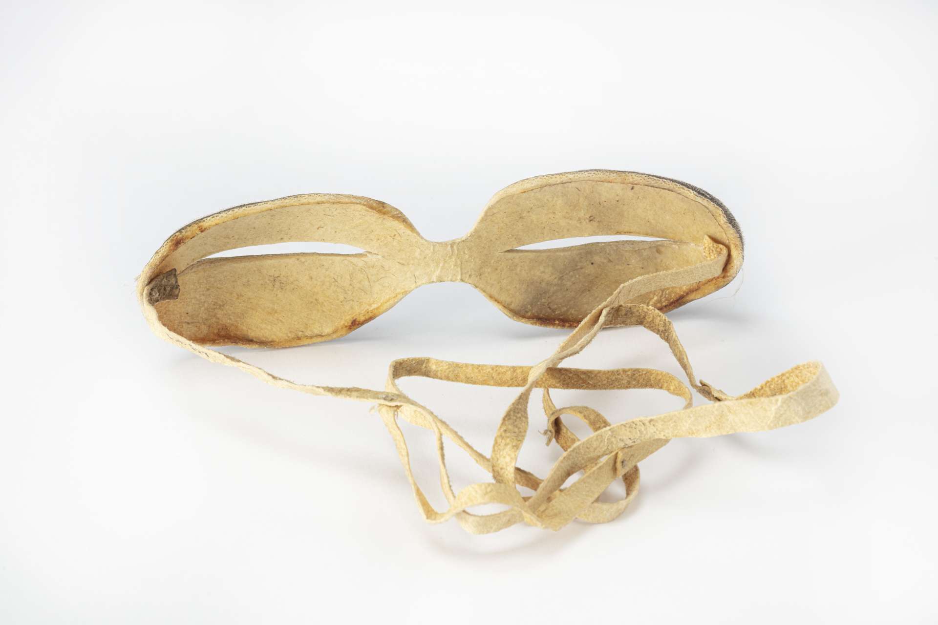 Lunettes en peau de phoque, vues de derri&egrave;re, montrant l&rsquo;int&eacute;rieur beige clair et la sangle attach&eacute;e aux extr&eacute;mit&eacute;s.