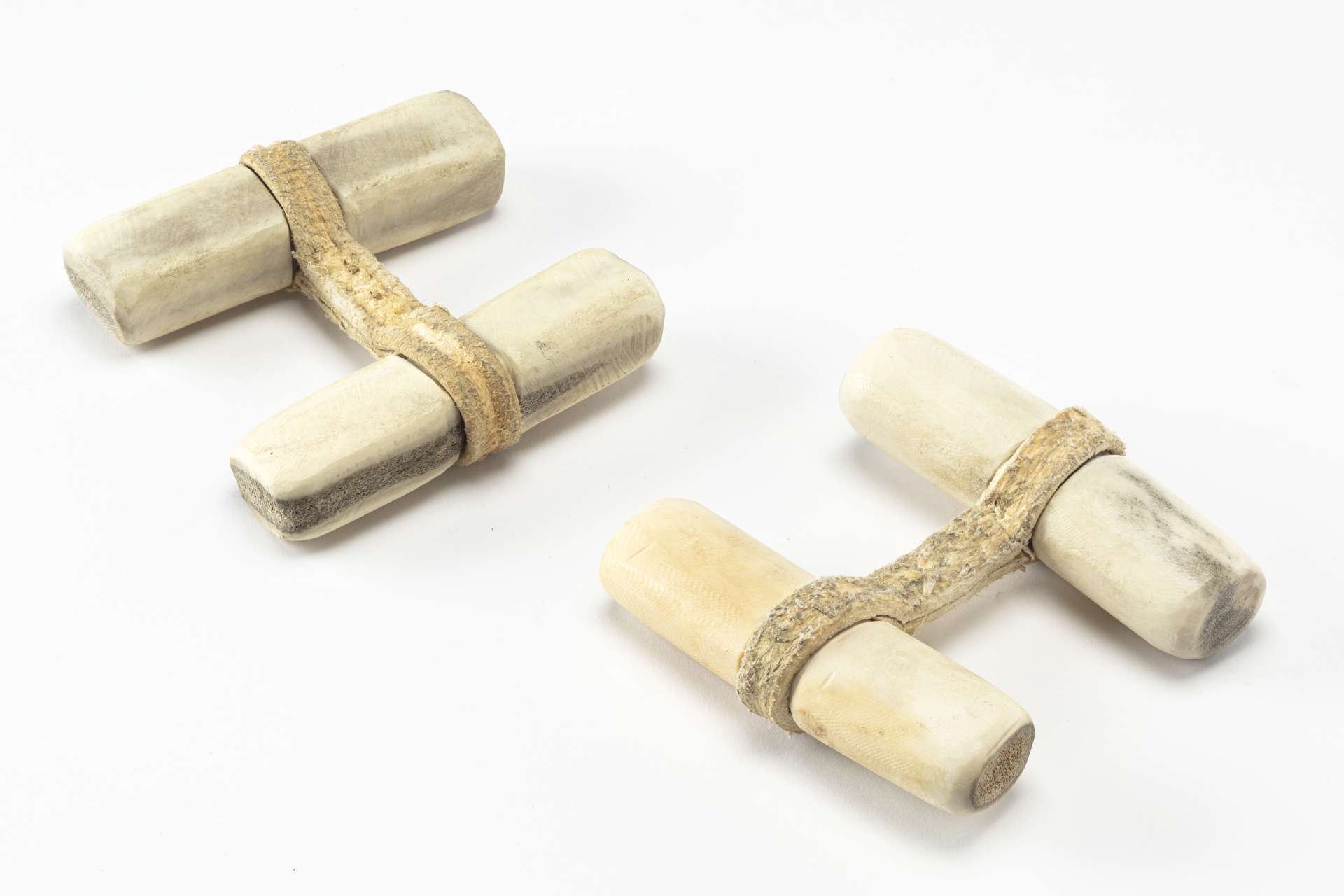 Deux jeux de force, en forme de H majuscule, compos&eacute;s chacun de deux poign&eacute;es cylindriques, attach&eacute;es par une large bande en cuir.