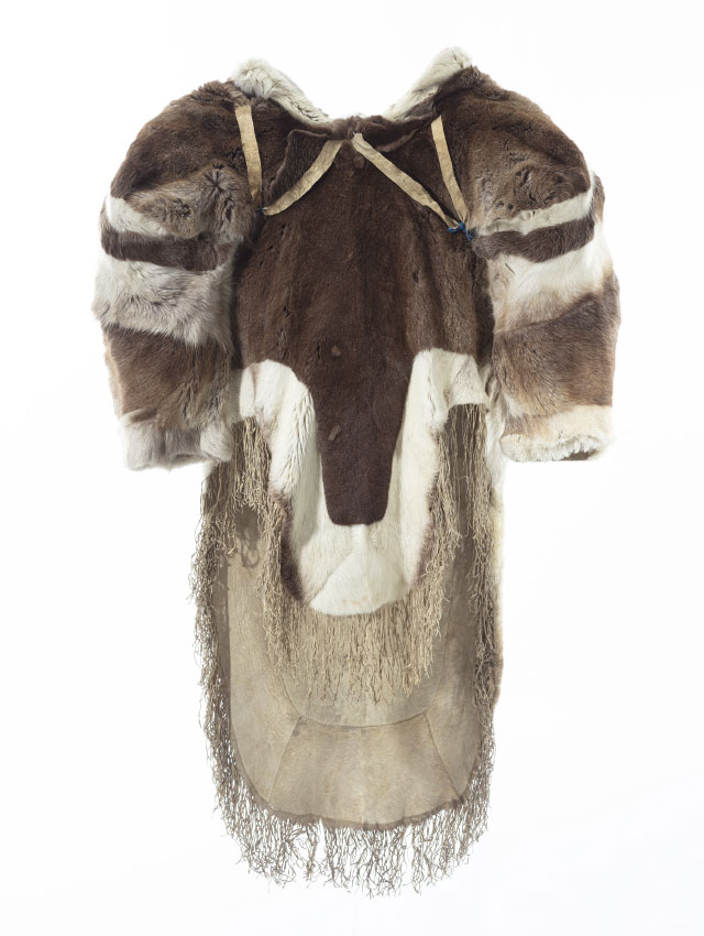 Manteau en fourrure vu en 360 degr&eacute;s, pr&eacute;sentant des &eacute;paules larges et un grand capuchon. La fourrure brune et blanche est agenc&eacute;e en bandes sur le capuchon et les &eacute;paules. Des sangles en forme de &laquo; V &raquo; sous les &eacute;paules sont visibles sur l&rsquo;avant du manteau. Le pan avant du manteau est plus court que le pan arri&egrave;re, qui sont tous deux bord&eacute;s de fourrure blanche et d&eacute;cor&eacute;s de franges au bas.